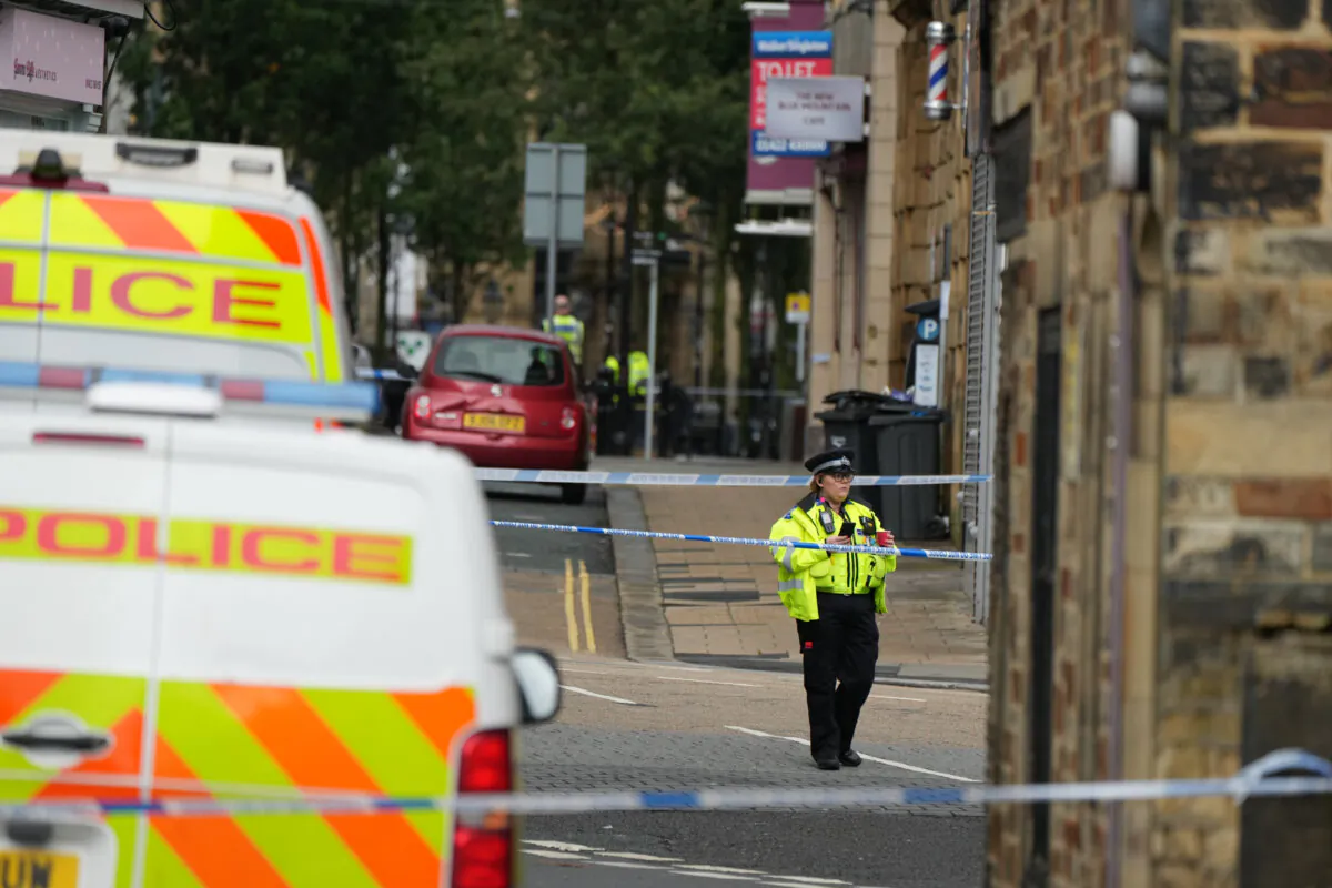 Police officers patrol near to the scene where two men were stabbed to death in Halifax, West Yorkshire, on Oct. 1, 2023. (Danny Lawson/PA)