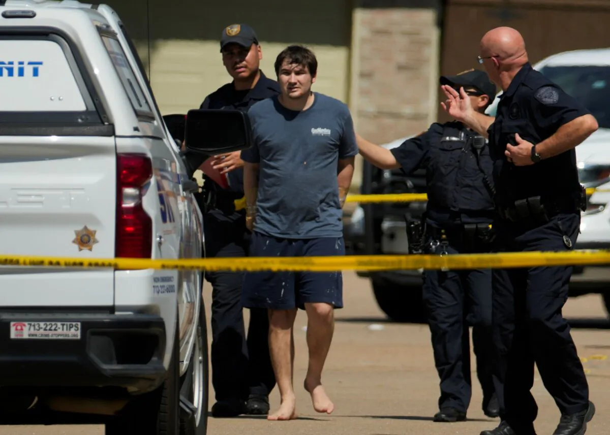 A man in handcuffs is taken by Harris County Sheriff's Office deputies as they respond to a scene of a shooting in Houston on Oct. 1, 2023. (Jason Fochtman/Houston Chronicle via AP)