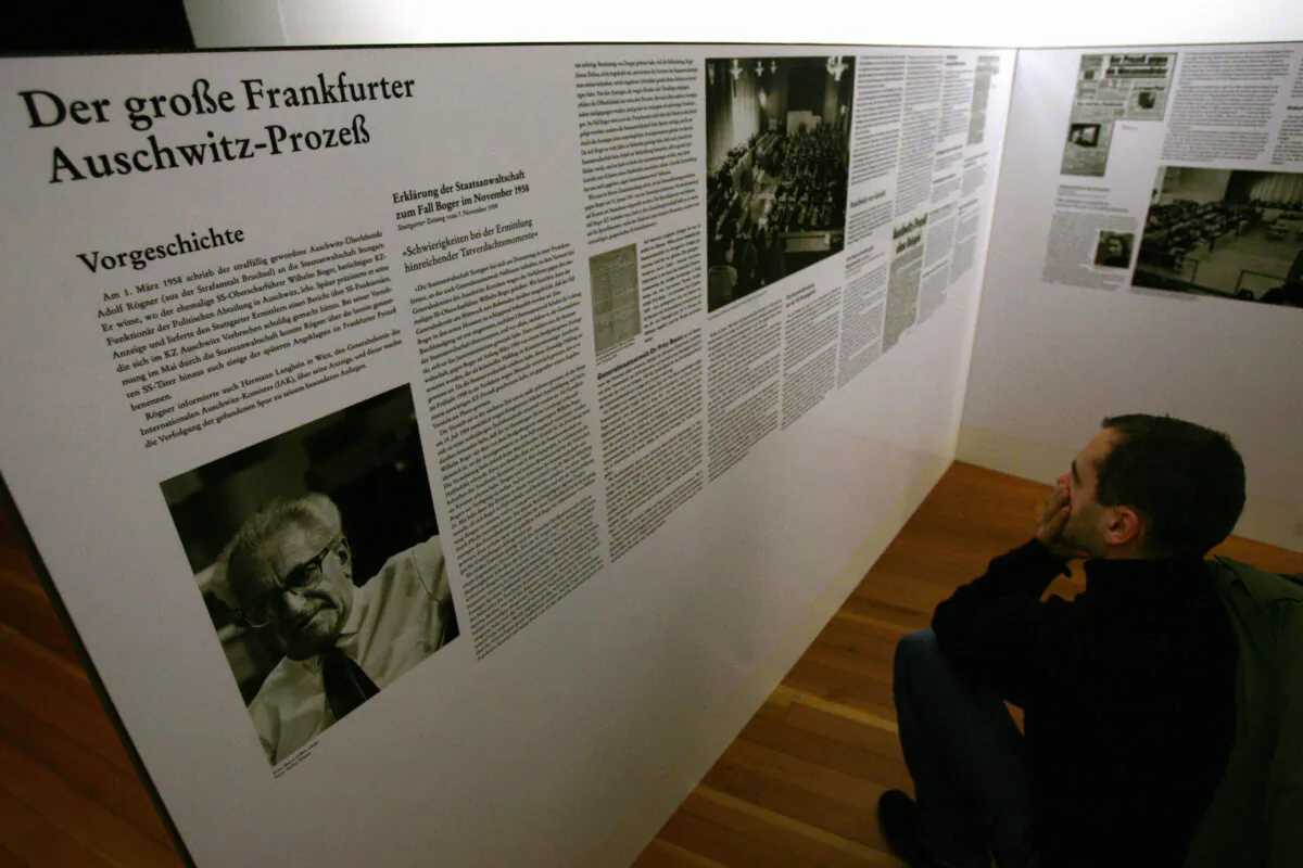 A visitor reads about the "Frankfurt Trial" of Auschwitz's Nazi commanders initiated in 1963, at an exhibition at the Martin Gropius Museum in Berlin on Nov. 14, 2004. (John Macdougall/AFP via Getty Images)