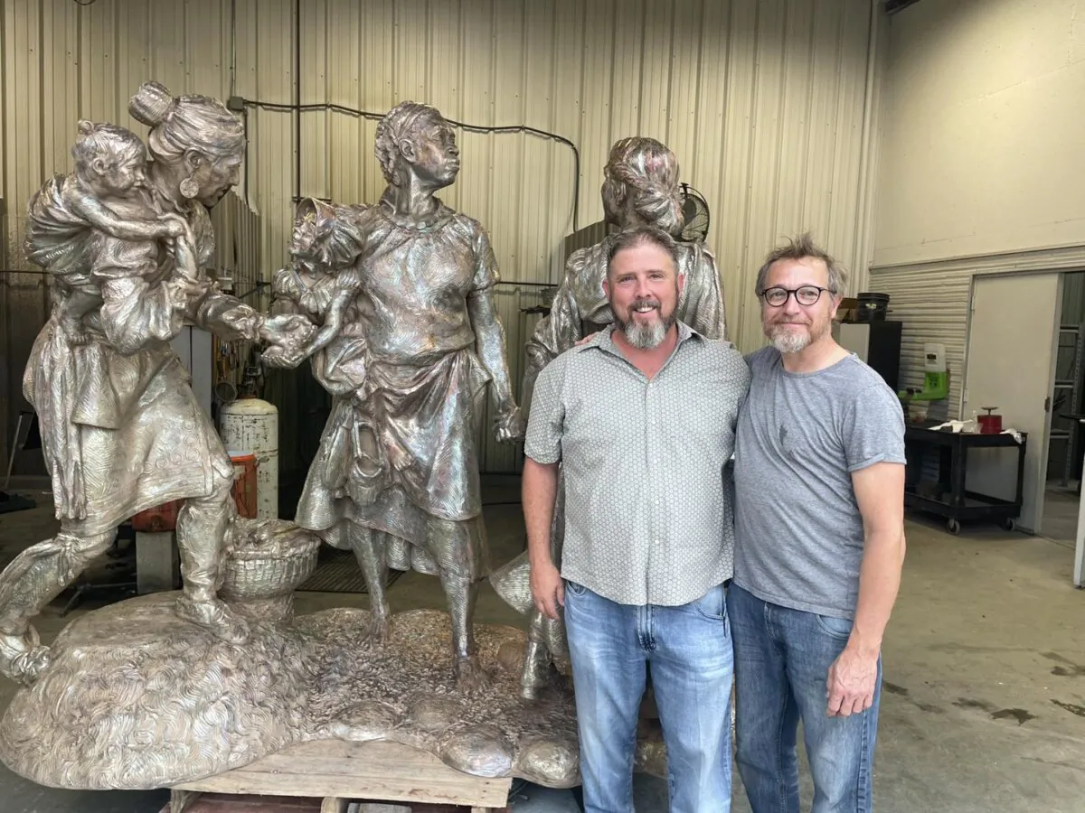 (L–R) Clint Howard, owner of Pyrology Foundry, and Wesley Wofford, sculptor, posing in front of "Sowing the Seeds for the Future." (Claire Suminski)