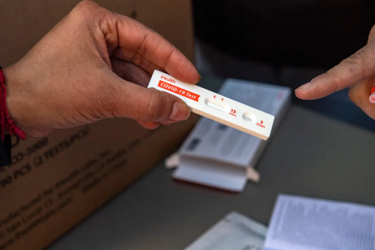 Volunteers explain how to use a rapid at-home COVID-19 test in Chelsea, Mass., on Dec. 17, 2021. (Joseph Prezioso/AFP via Getty Images)