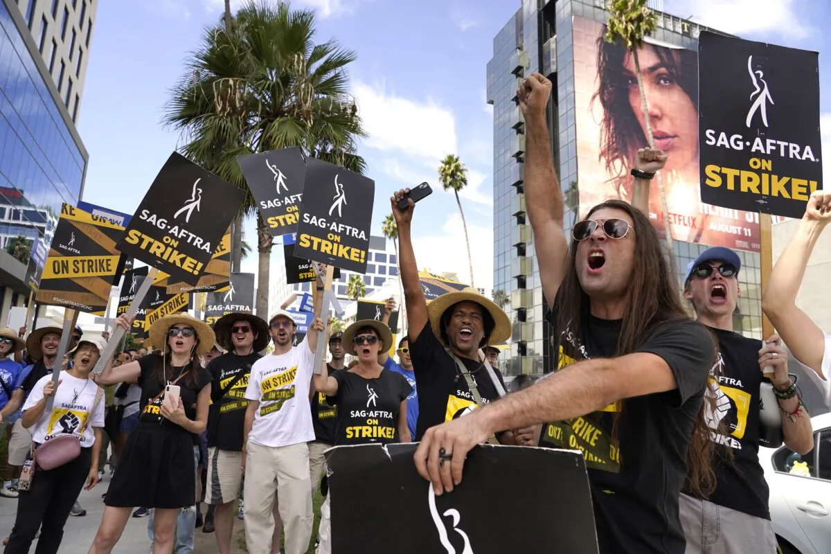 SAG-AFTRA member John Schmitt (2nd R) and others carry signs on the picket line outside Netflix in Los Angeles on Sept. 27, 2023. (Chris Pizzello/AP Photo)