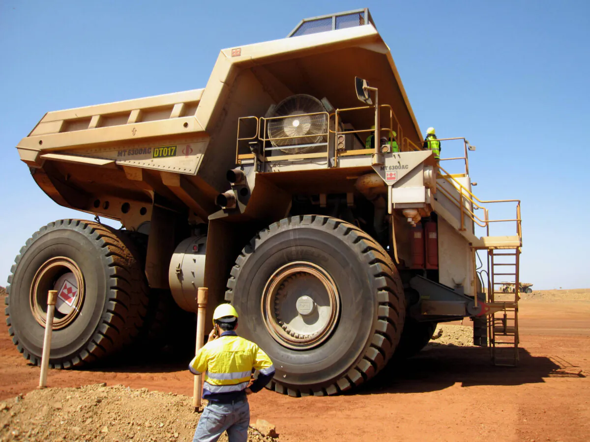 This photo taken shows a worker in front of a massive dump truck in Pilbara, Western Australia, on March 5, 2010. (Amy Coopes/AFP via Getty Images)