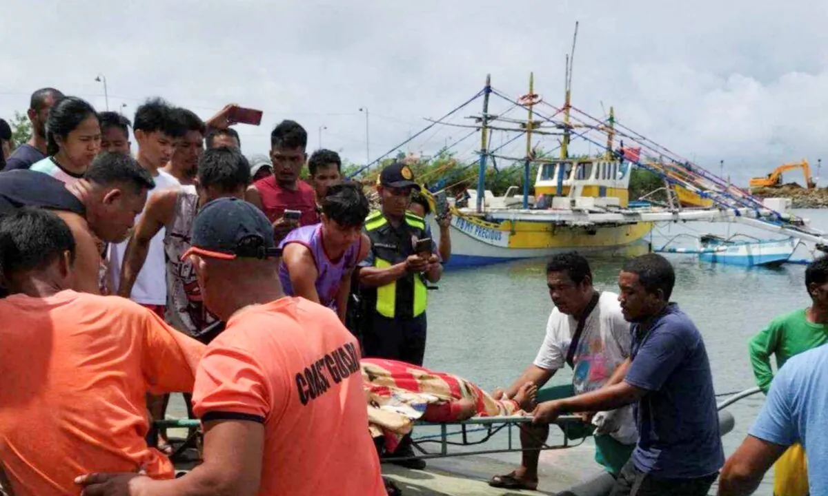 The rescuers carry the body of one of the victims as it arrives at a port in Infanta, Pangasinan province, Philippines, on Oct. 3, 2023. (Philippine Coast Guard via AP)