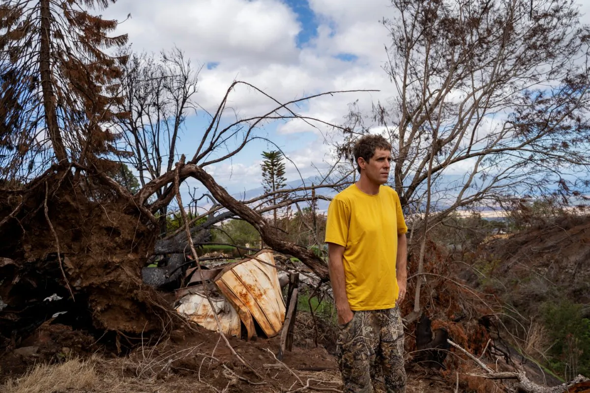 Kyle Ellison stands in front of a fallen tree in Kula, Hawaii on Sept. 27, 2023. (Mengshin Lin/AP Photo)
