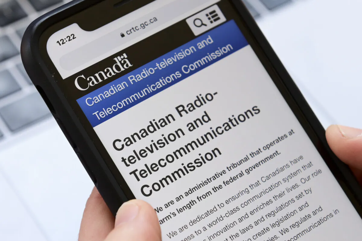A person navigates to the online social media pages of the Canadian Radio-television and Telecommunications Commission (CRTC) on a cell phone in Ottawa on May 17, 2021. (The Canadian Press/Sean Kilpatrick)
