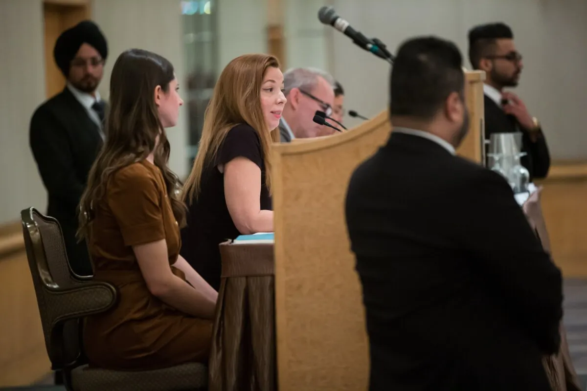 Security surrounds the stage as writer Meghan Murphy, centre, speaks during a panel discussion on gender identity in Vancouver, Nov. 2, 2019. (Darryl Dyck/The Canadian Press)