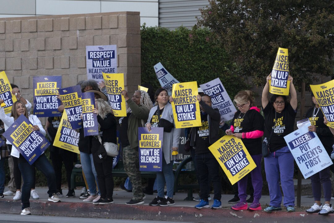 Kaiser Permanente workers carry protest signs outside the hospital during a strike in the Panorama City section of Los Angeles on Oct. 4, 2023. (Richard Vogel/AP Photo)