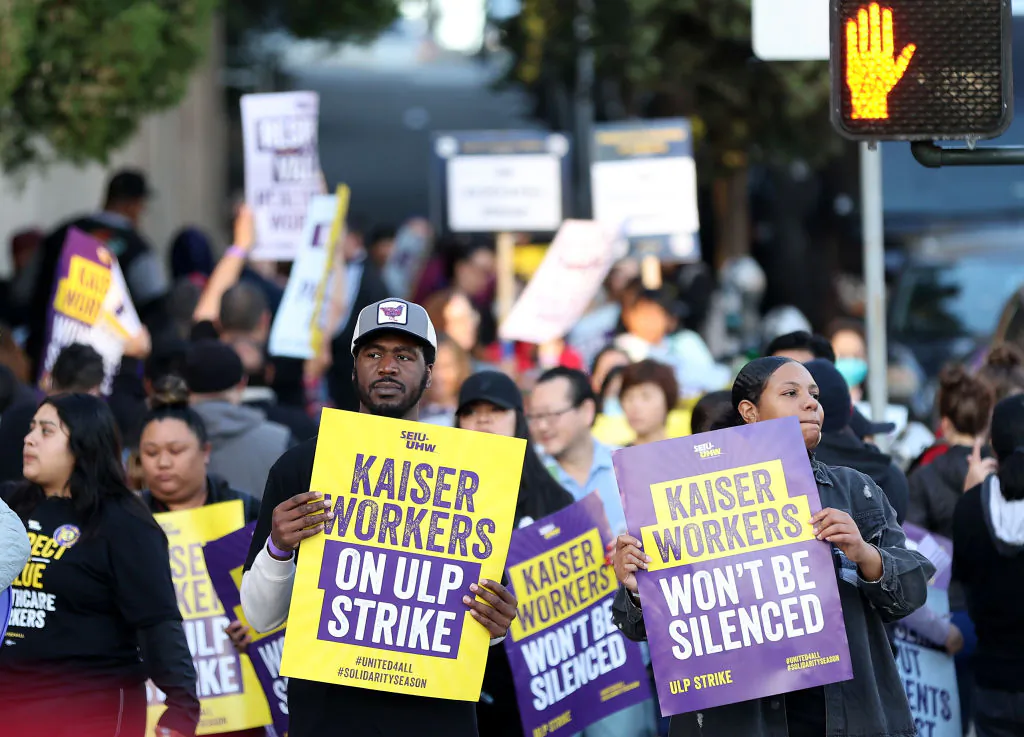 Striking Kaiser Permanente workers hold signs as they march in front of the Kaiser Permanente San Francisco Medical Center in Calif., on Oct. 4, 2023. (Justin Sullivan/Getty Images)