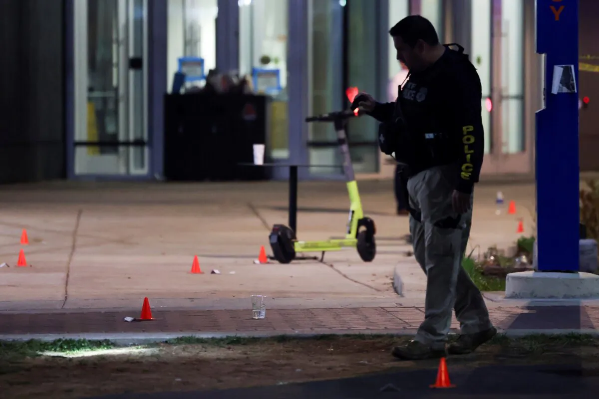 A police officer searches for evidence in front of a building at Morgan State University after a shooting in Baltimore on Oct. 4, 2023. (Julia Nikhinson/AP Photo)
