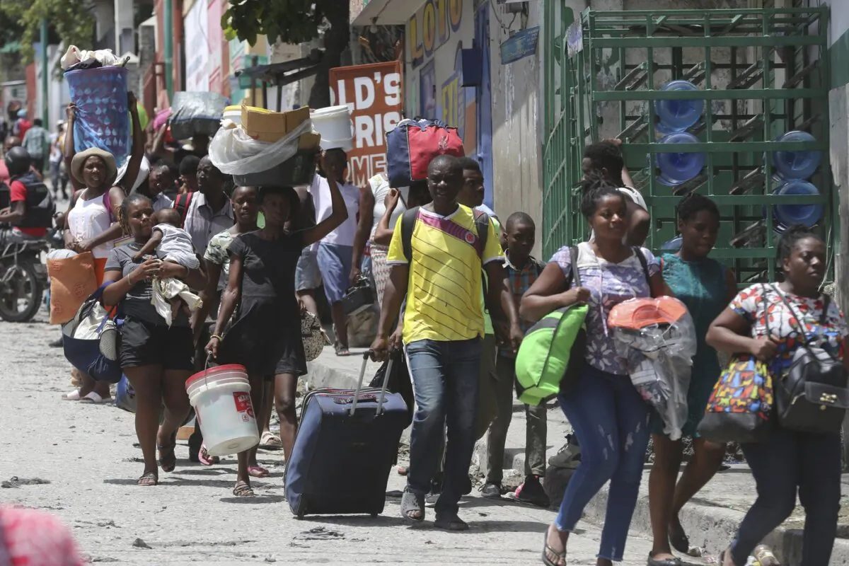 Residents flee their homes to escape clashes between armed gangs in the Carrefour-Feuilles district of Port-au-Prince, Haiti, on Aug. 15, 2023. (The Canadian Press/AP-Odelyn Joseph)