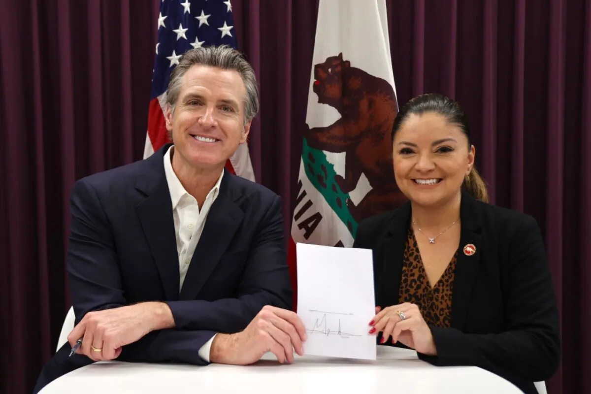 California Gov. Gavin Newsom (L) signs SB 616 authored by Sen. Lena Gonzalez (R), D-Long Beach, to give workers five sick days a year instead of three, on Oct. 4, 2023. (Courtesy of Office of Governor Gavin Newsom)