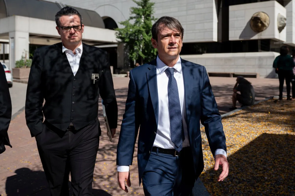 Cameron Ortis (R) a former RCMP intelligence director accused of disclosing classified information, leaves the Ottawa Courthouse following a break in proceedings on Oct. 3, 2023. (The Canadian Press/Spencer Colby)