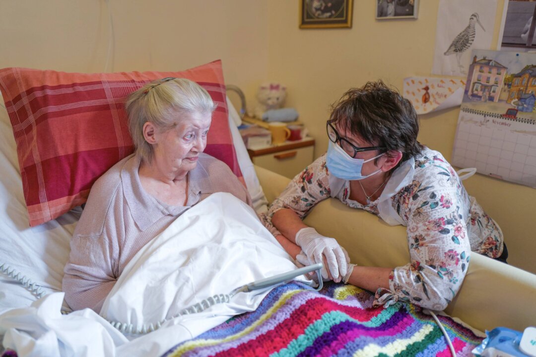 Care home resident Dot Hendy holds her daughter Louise's hand for the first time since March after Louise successfully passed a Rapid COVID-19 Test immediately before meeting her mother at the King Charles Court Care Home, Falmouth, England, on Nov. 18, 2020. (Hugh Hastings/Getty Images)