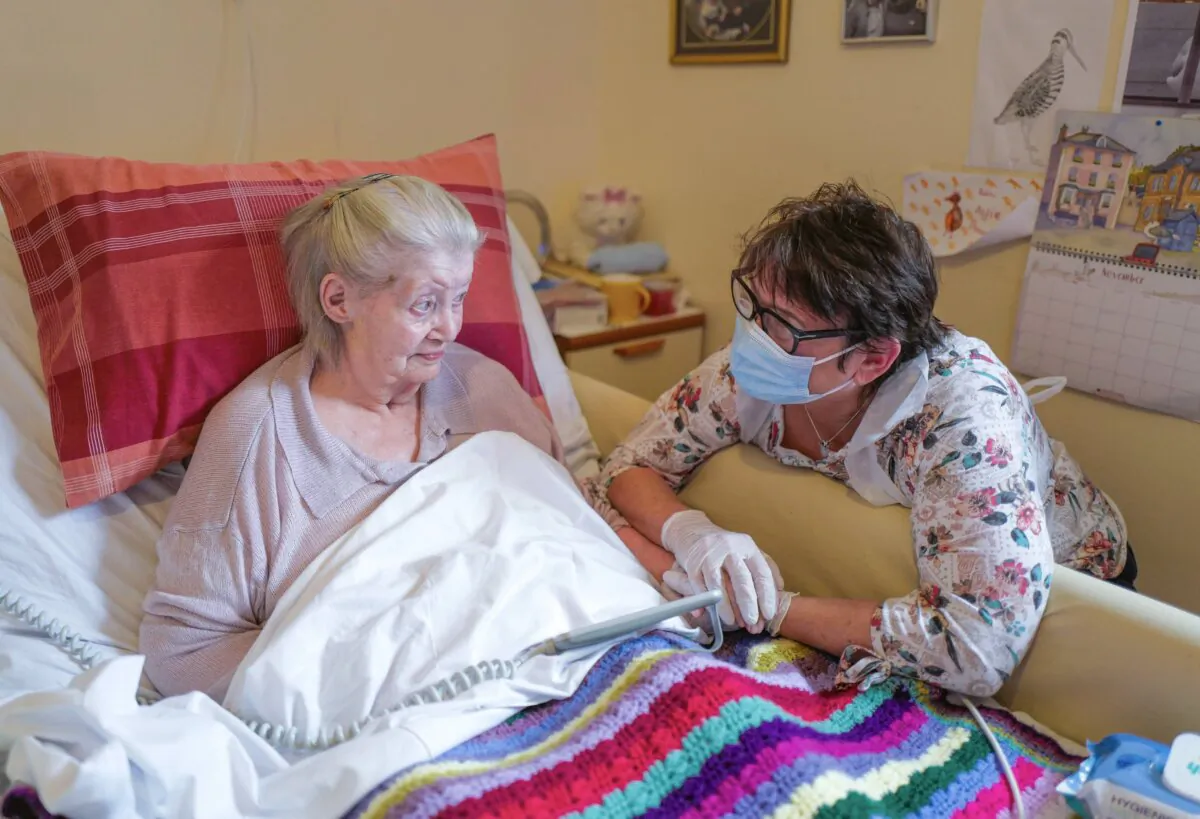 Care home resident Dot Hendy holds her daughter Louise's hand for the first time since March after Louise successfully passed a Rapid COVID-19 Test immediately before meeting her mother at the King Charles Court Care Home, Falmouth, England, on Nov. 18, 2020. (Hugh Hastings/Getty Images)