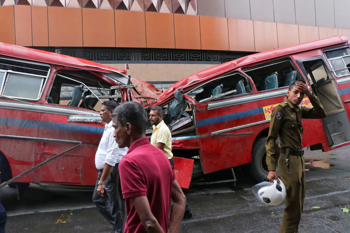 A security officer stands by a bus that was damaged when a tree fell on it in Colombo, Sri Lanka, on Oct. 6, 2023. (AP Photo)