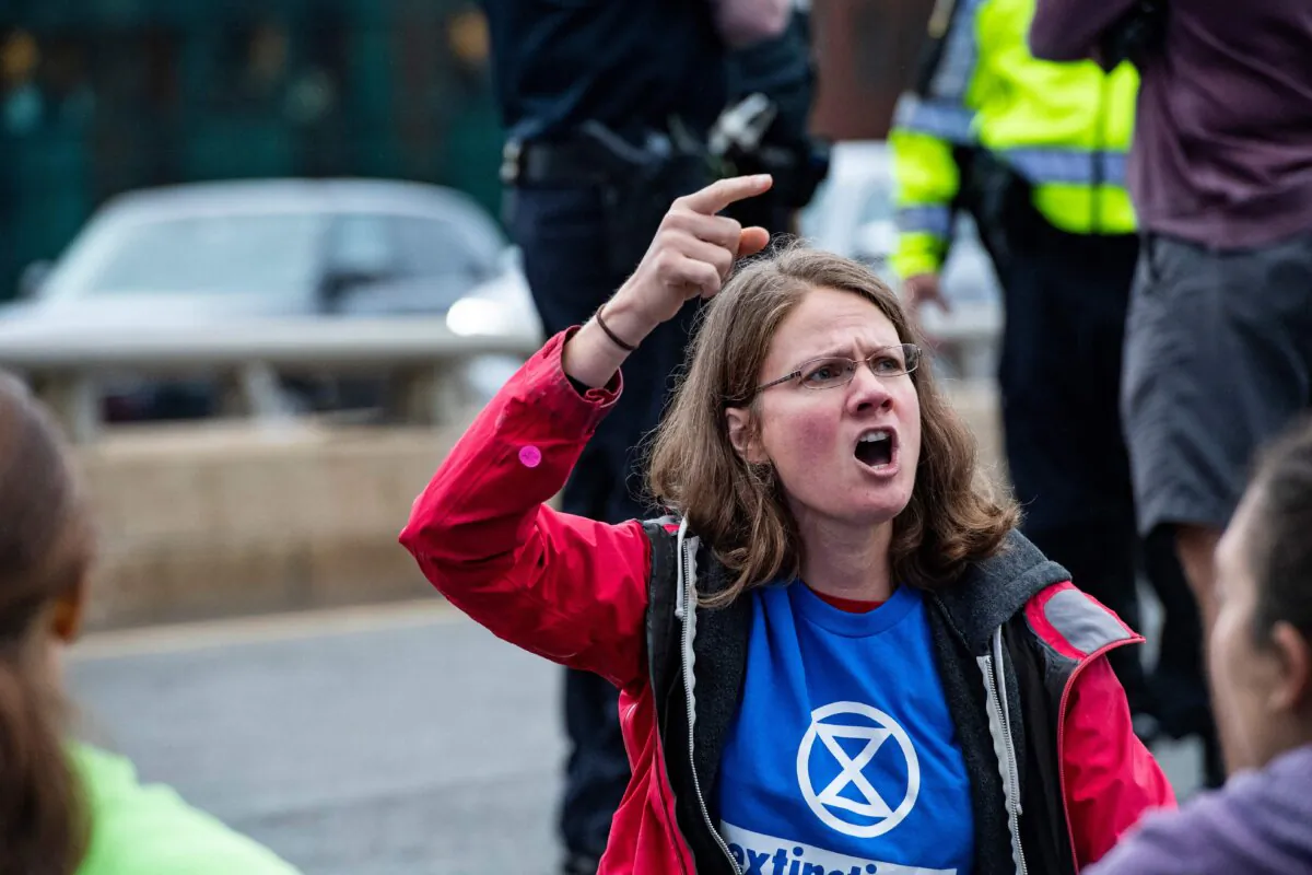 Climate activists from the group Extinction Rebellion yell while blocking traffic in Boston, Massachusetts, on September 21, 2022. (Photo by JOSEPH PREZIOSO/AFP via Getty Images)
