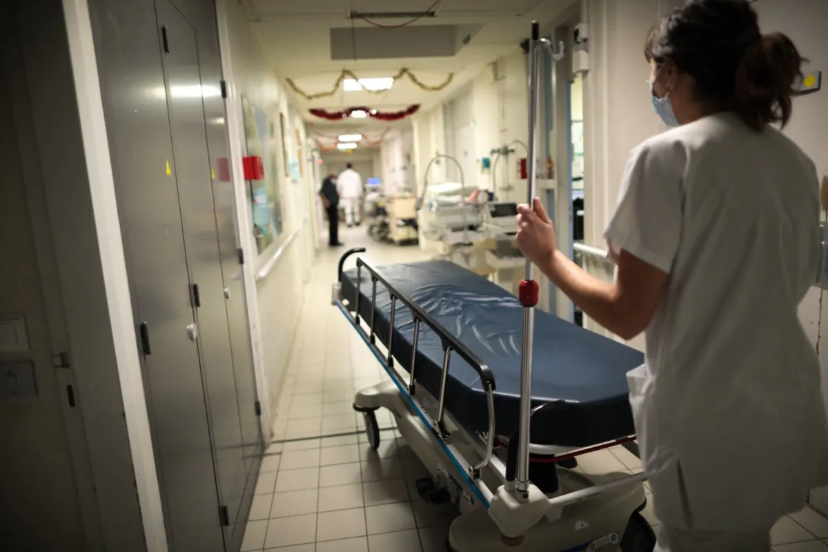 A care worker carries a bed in the emergency department of a hospital in a file photo. (Lou Benoist/AFP via Getty Images)