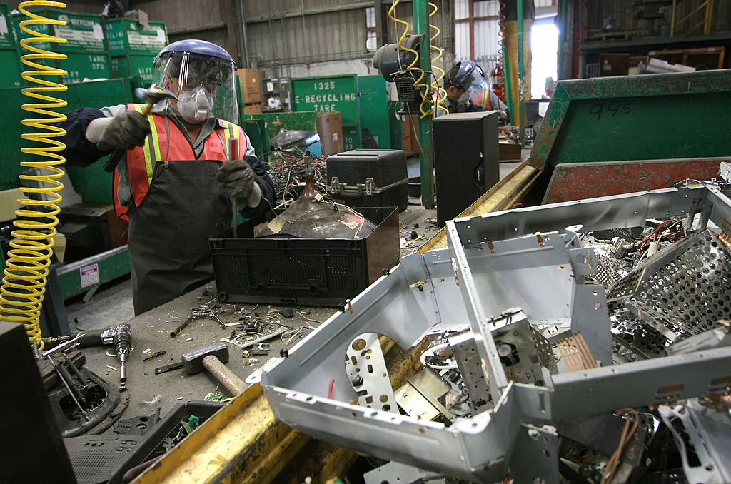 A worker at E Recycling dismantles an old analog television in Hayward, Calif., on Jan. 28, 2009. (Justin Sullivan/Getty Images)