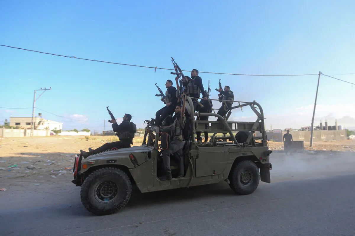 Palestinian militants ride an Israeli military vehicle that was seized by gunmen who infiltrated areas of southern Israel, in the northern Gaza Strip October 7, 2023. REUTERS/Ahmed Zakot