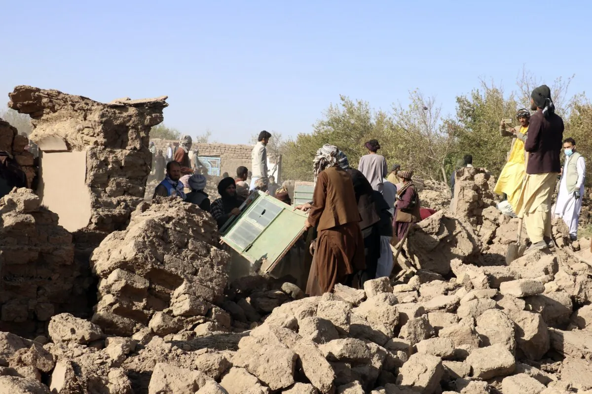 Afghan men clear the debris after an earthquake in Zenda Jan district in Herat province, of western Afghanistan, on Oct. 8, 2023. (Omid Haqjoo/AP Photo)