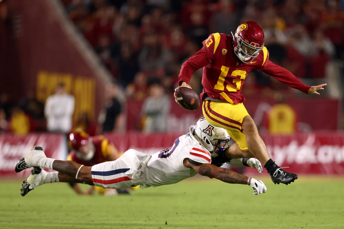 Caleb Williams (13) of the USC Trojans avoids a tackle from Justin Flowe (10) of the Arizona Wildcats during the third quarter at United Airlines Field at the Los Angeles Memorial Coliseum in Los Angeles on Oct. 7, 2023. (Katelyn Mulcahy/Getty Images)