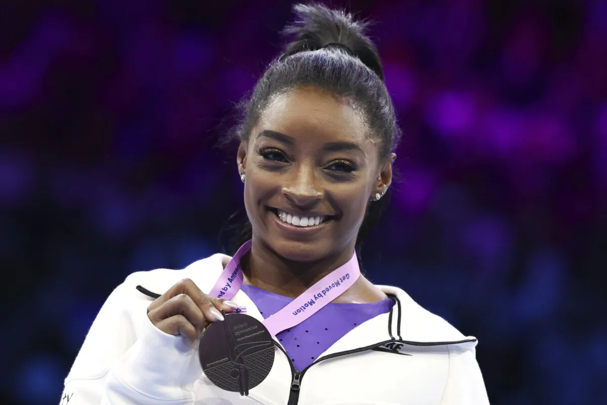 Simone Biles of the United States shows her gold medal on the beam during the apparatus finals at the Artistic Gymnastics World Championships in Antwerp, Belgium, on Oct. 8, 2023. (Geert vanden Wijngaert/AP Photo)
