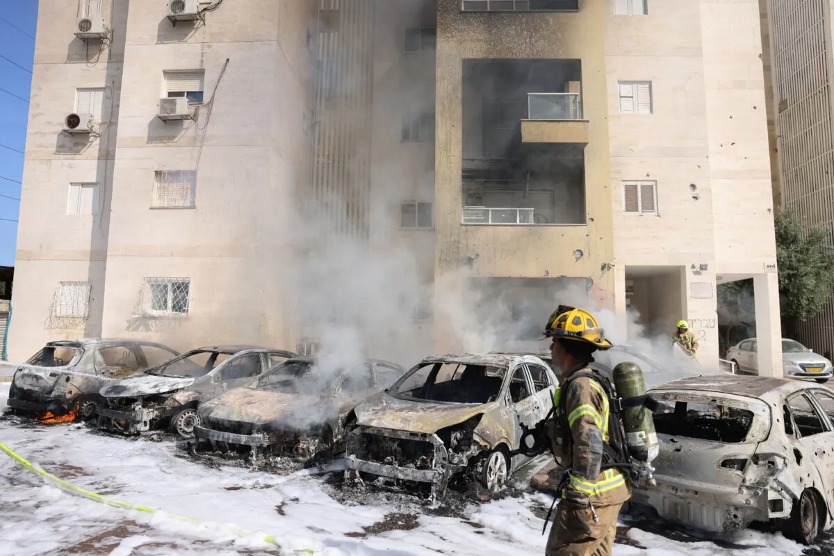 Israeli fire brigade teams douse the blaze in a parking lot outside a residential building following a rocket attack from the Gaza Strip in the southern Israeli city of Ashkelon, on Oct. 7, 2023. Palestinian militants have begun a "war" against Israel, the country's defense minister said on Oct. 7 after a barrage of rockets were fired and fighters from the Palestinian enclave infiltrated Israel, a major escalation in the Israeli-Palestinian conflict. (Ahmad Gharabli/AFP via Getty Images)