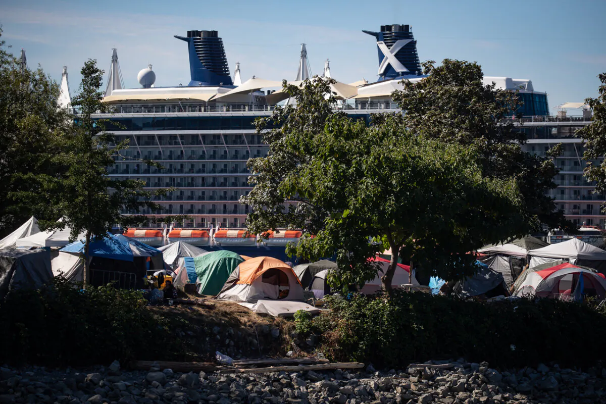 Tents and people are seen at a homeless encampment at Crab Park as the Celebrity Cruises vessel Celebrity Eclipse is docked at port in Vancouver, on Aug. 14, 2022. (The Canadian Press/Darryl Dyck)