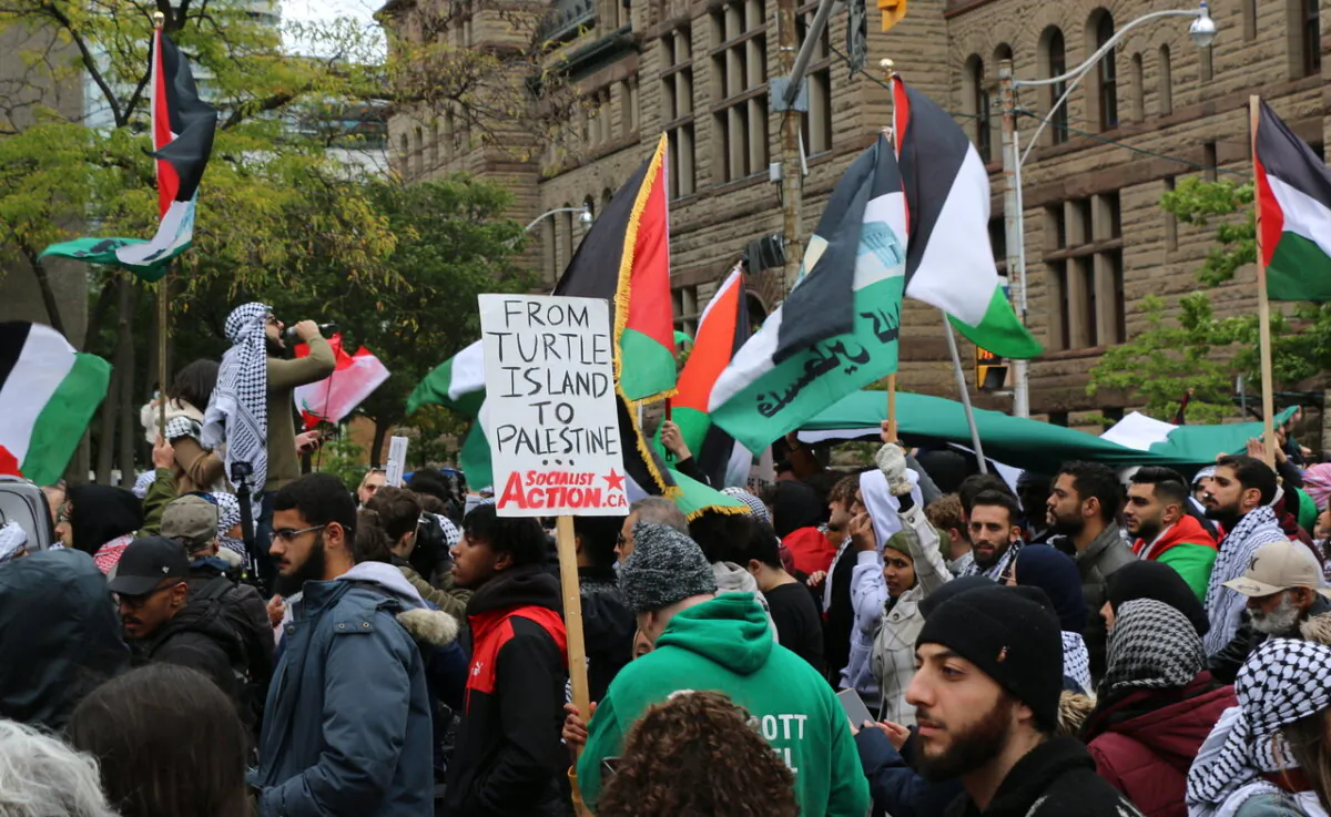 Pro-Palestine protesters hold flags and banners as they march along Bay Street in downtown Toronto on Oct. 9, 2023. (Andrew Chen/The Epoch Times)