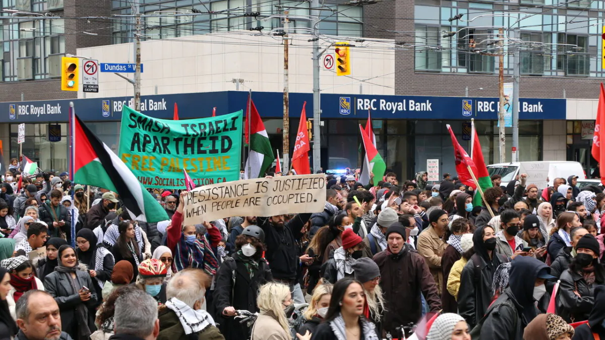 Pro-Palestine protesters were seen holding large banners, including one that reads "Smash Israeli Apartheid, Free Palestine," and another that reads "Resistance is Justified When People Are Occupied." Protesters marched along Bay Street in downtown Toronto on Oct. 9, 2023. (Andrew Chen/The Epoch Times)