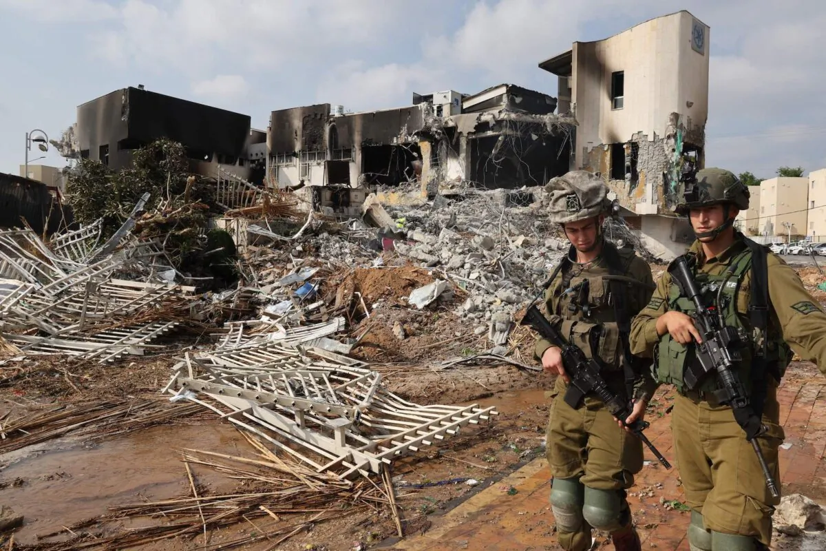 Soldiers walk in front of an Israeli police station that was damaged during battles to dislodge Hamas militants who were stationed inside, on Oct. 8, 2023. Israel's prime minister on Oct. 8 warned of a "long and difficult" war, as fighting with Hamas left hundreds killed on both sides after a surprise attack on Israel by the Palestinian militant group. (Jack Guez/AFP via Getty Images)