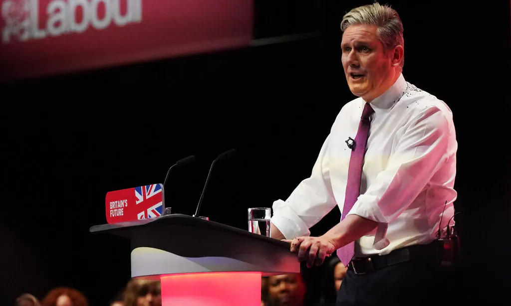 Labour party leader, Sir Keir Starmer delivers the leader's speech, covered in glitter after a protester stormed the stage on the third day of the Labour Party conference in Liverpool, England on October 10, 2023. (Ian Forsyth/Getty Images)