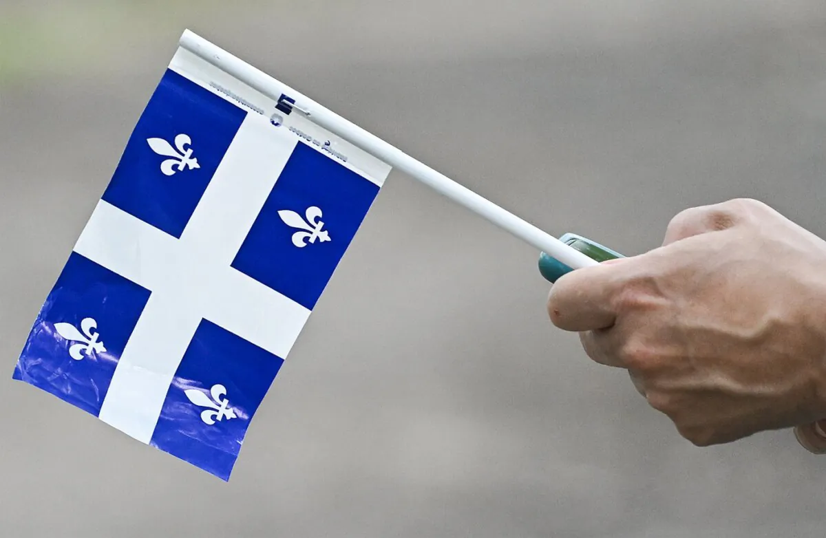A person holds a Quebec flag on St-Jean-Baptiste Day in Montreal, on June 24, 2023. (The Canadian Press/Graham Hughes)