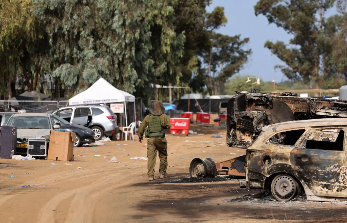 An Israeli soldier walks past burnt-out vehicles near Kibbutz Re’im in southern Israel after the attack on the Supernova music festival by Hamas terrorists, on Oct. 10, 2023. (Jack Guez/AFP via Getty Images)