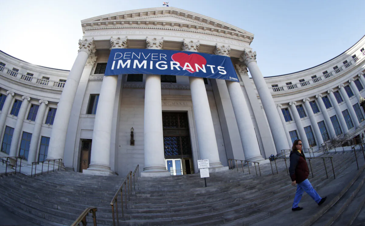 A banner to welcome immigrants is viewed through a fisheye lens over the main entrance to the Denver City and County Building in Denver. (David Zalubowski/Associated Press)