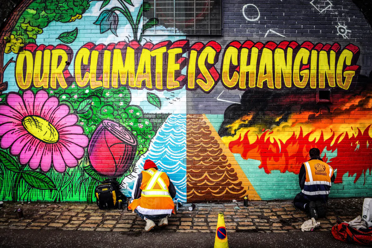 Street artists paint a mural as part of the Grantham Climate Art Prize 2021 on a wall near the COP26 climate summit venue in Glasgow, Scotland, on Oct. 13, 2021. (Andy Buchanan/AFP via Getty Images)