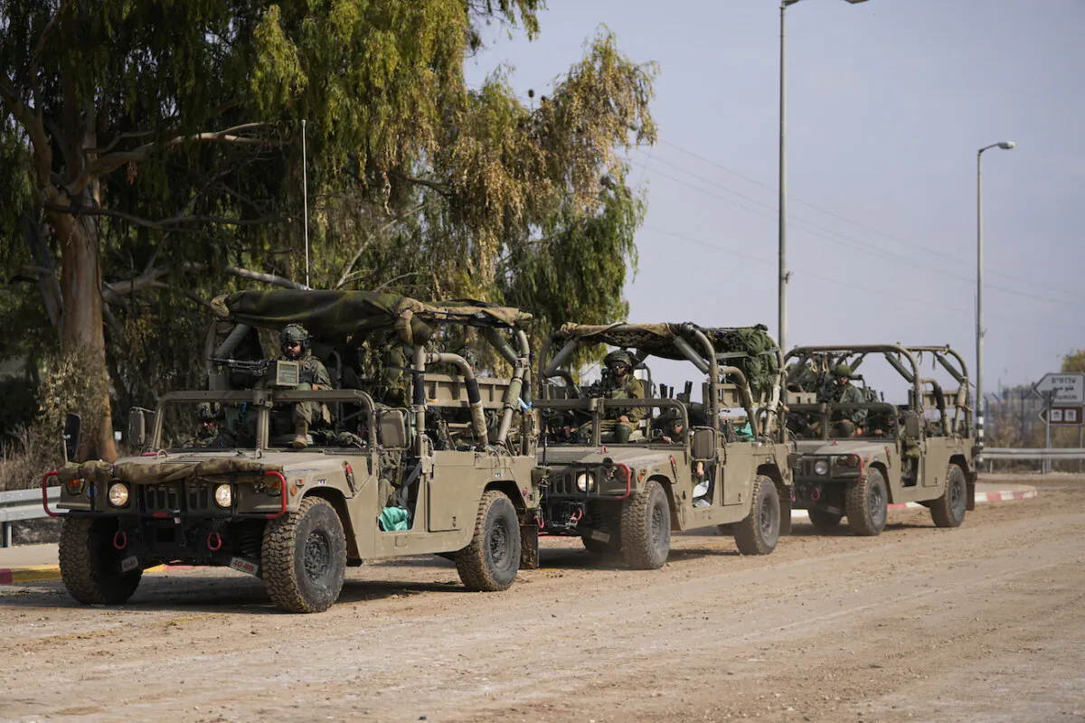 Israeli soldiers drive by the rave party site, where scores were killed, near the Kibbutz Re'im, close to the Gaza Strip border fence, on Oct.10, 2023. (AP Photo/Ohad Zwigenberg)