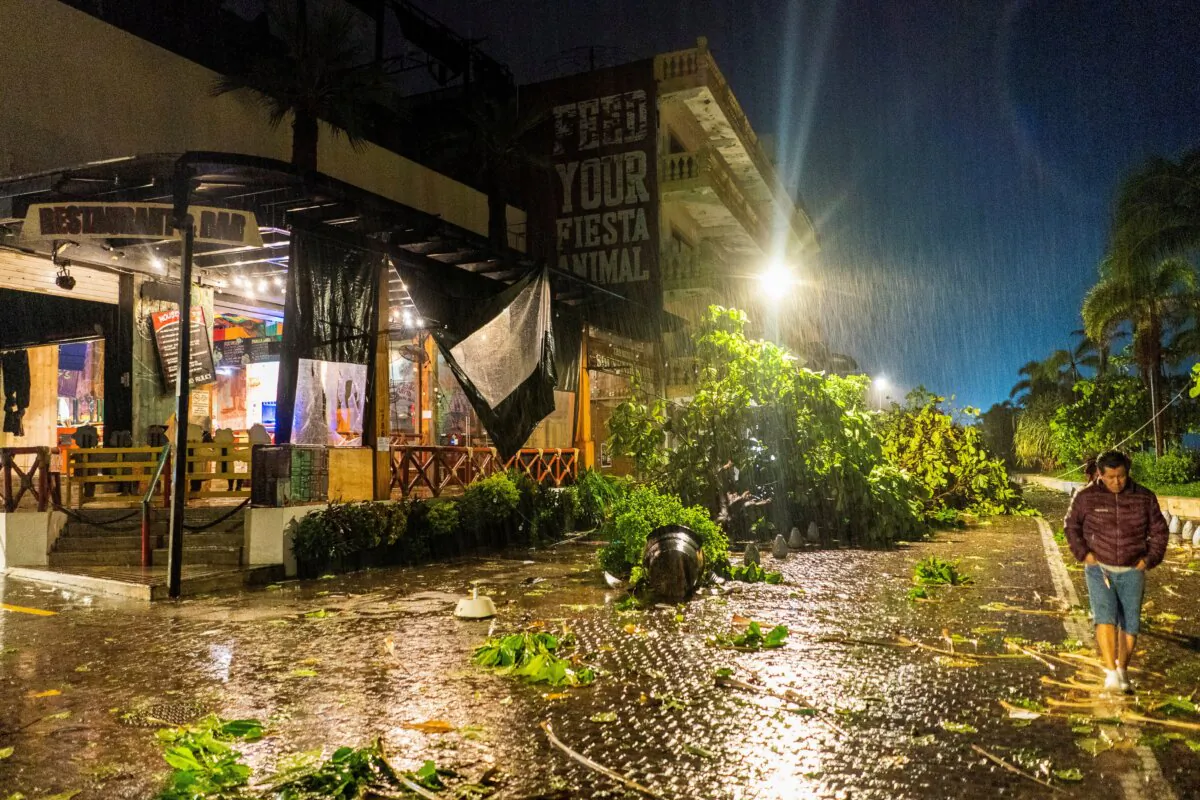 People walk by a restaurant damaged in the aftermath of Hurricane Lidia, in Puerto Vallarta, Mexico, on Oct. 10, 2023. (Christian Ruano/Reuters)