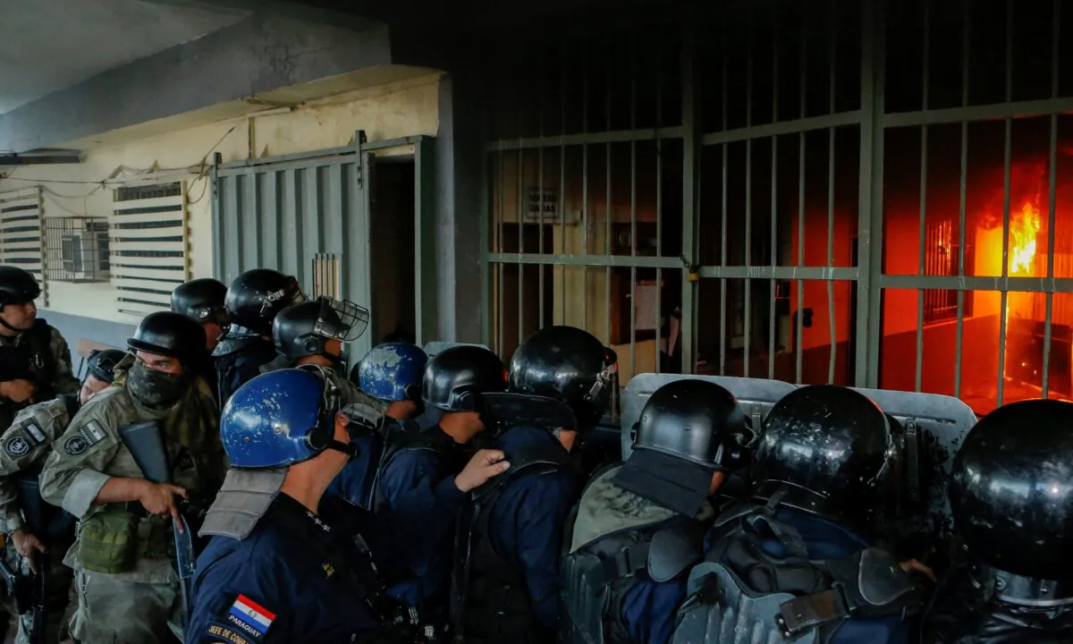 Police stand outside the Tacumbu penitentiary during a riot after inmates took hostage a dozen officials and caused a fire, in Asuncion, Paraguay, on Oct. 10, 2023. (Cesar Olmedo/Reuters)