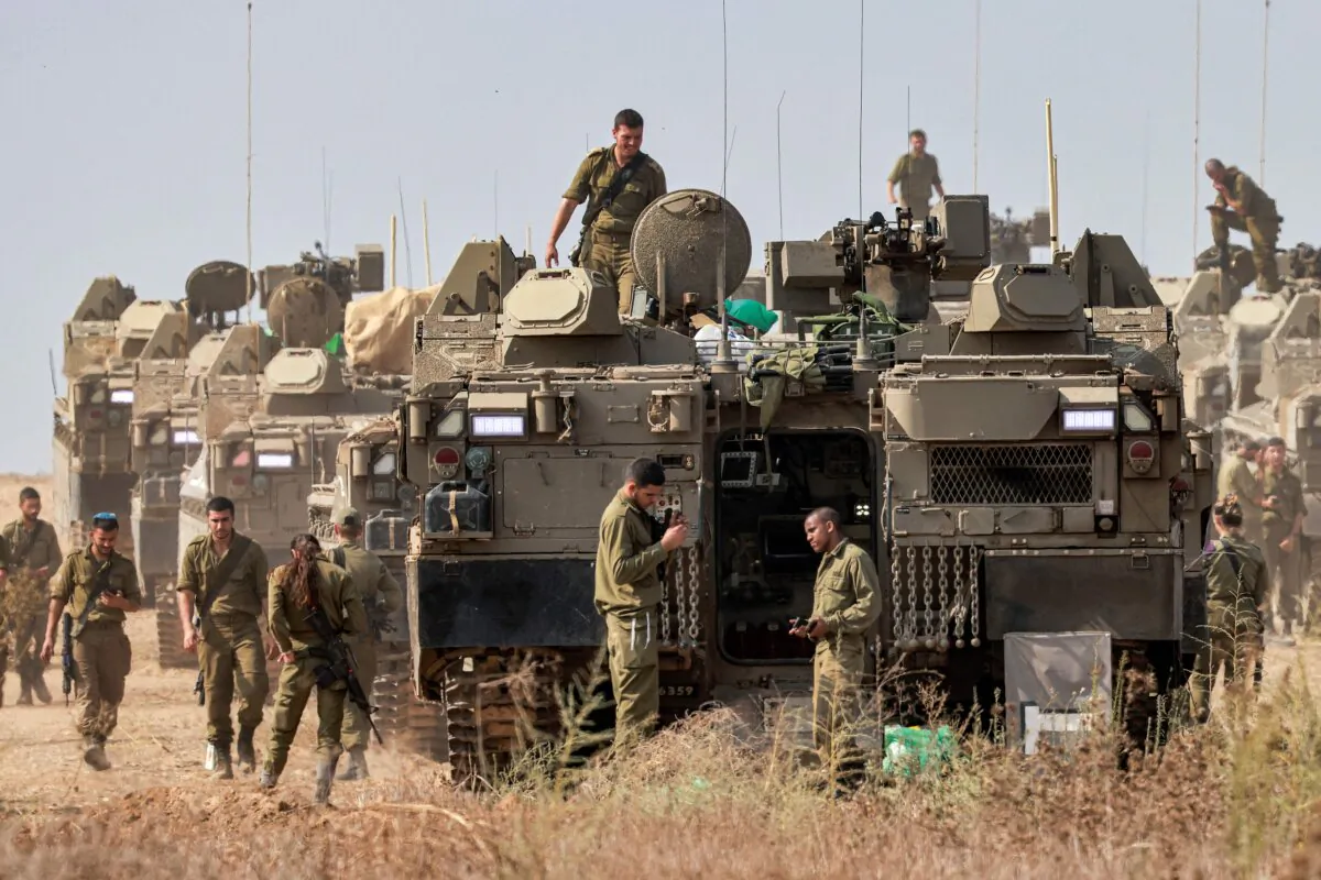 Israeli army soldiers stand near their Namer armored personnel carriers (APCs) at a position near the border with Gaza in southern Israel on Oct. 11, 2023. (Menahem Kahana/AFP via Getty Images)