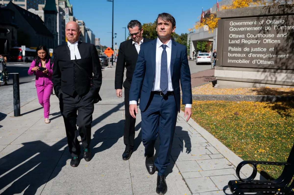 Cameron Jay Ortis (R) a former RCMP intelligence director accused of disclosing classified information, leaves the Ottawa Courthouse following a break in proceedings in Ottawa on Oct. 3, 2023. (The Canadian Press/Spencer Colby)
