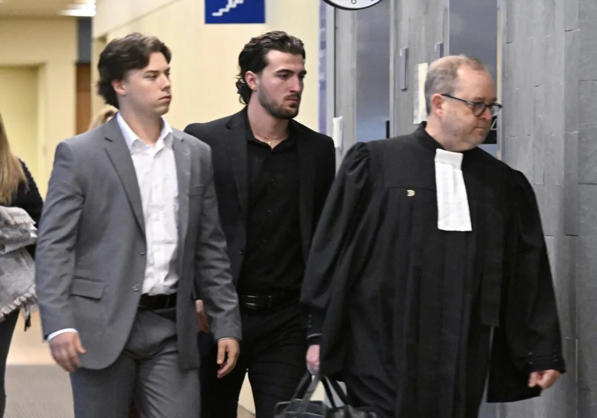 Former Victoriaville Tigres junior major hockey league players Nicolas Daigle (L) and Massimo Siciliano, follow defense lawyer Michel Lebrun (R) as they leave the courtroom in Quebec City on Oct. 11, 2023. (The Canadian Press/Jacques Boissinot)
