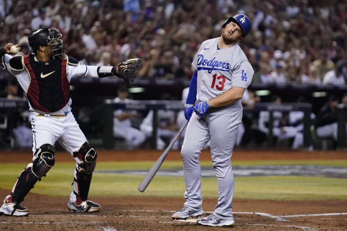 Los Angeles Dodgers' Max Muncy (13) reacts after a foul tip was caught by Arizona Diamondbacks catcher Gabriel Moreno, left, during the fourth inning in Game 3 of a baseball NL Division Series in Phoenix on Oct. 11, 2023. (Ross D. Franklin/AP Photo)