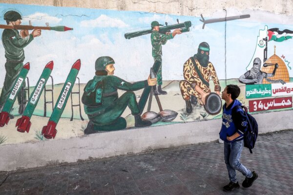 A child walks past a mural as Palestinians mark the 34th anniversary of the founding of the Islamist Hamas terrorist movement which rules the Palestinian strip, on Dec.11, 2021. (Said Khatib/AFP via Getty Images)