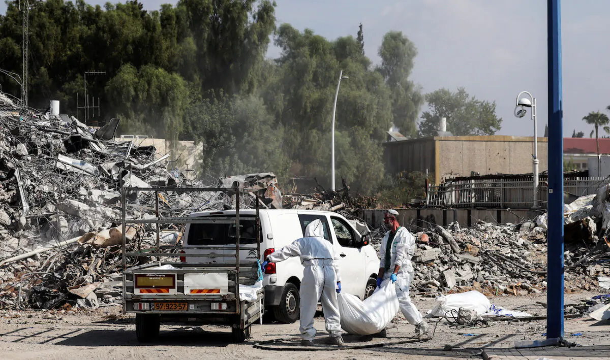 Israeli rescue workers remove dead bodies from near a destroyed police station that was the site of a battle following a mass-infiltration by Hamas terrorists from the Gaza Strip, in Sderot, southern Israel, on Oct. 11, 2023. (Violeta Santos Moura/Reuters)