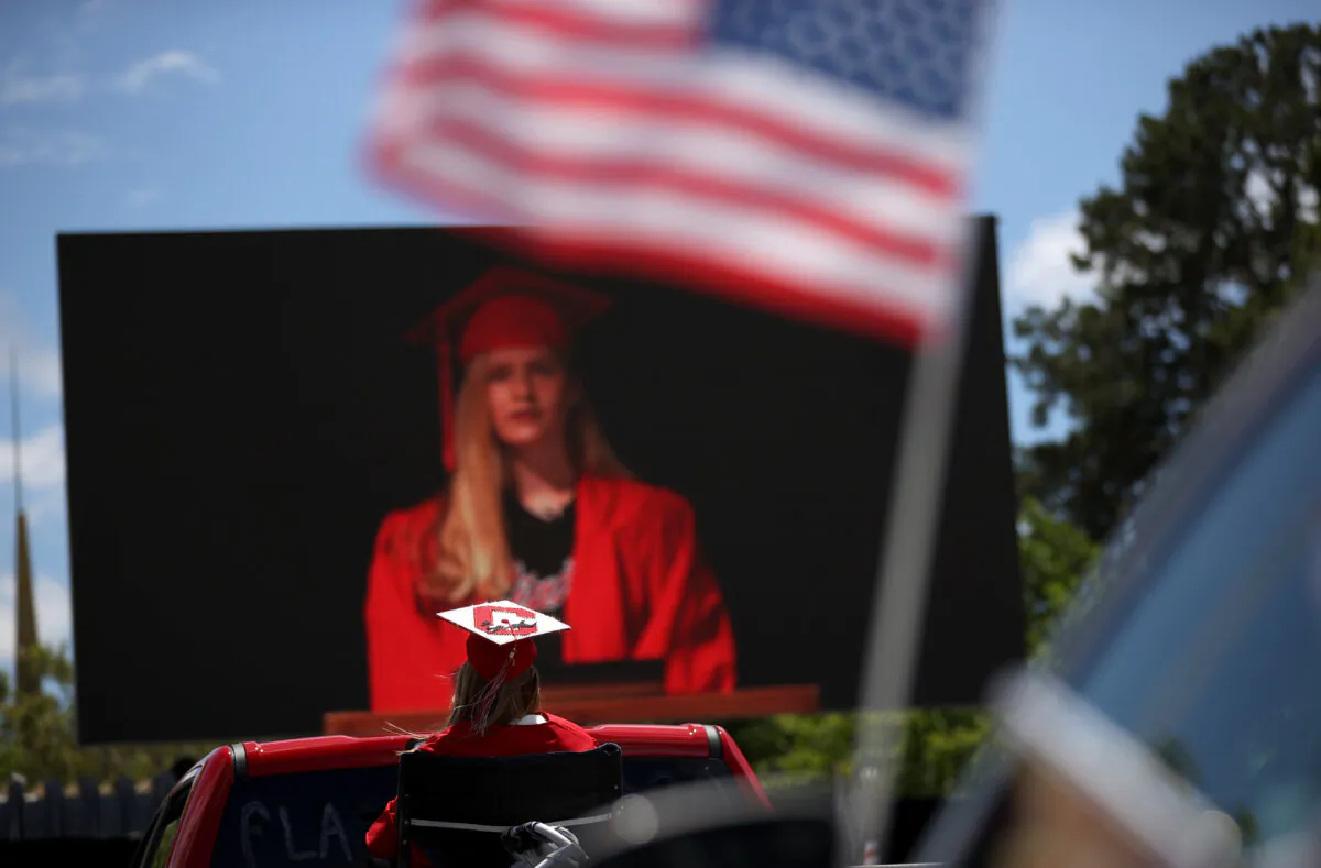 A Redwood High School senior watches a video screen presentation during a drive-in graduation ceremony at the Marin County Fairgrounds in San Francisco, California, on June 12, 2020. (Justin Sullivan/Getty Images)