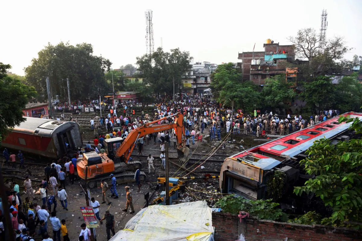 Rescuers and other gather around coaches of the North-East Express passenger train that derailed late Wednesday near Raghunathpur railroad station in Buxar district of Bihar state, India, on Oct.12, 2023. (Aftab Alam Siddiqui/AP)