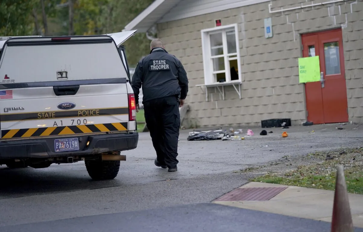 A trooper from the Pennsylvania State Police Reconstruction Unit works at the crime scene of a fatal shooting at the Chevy Chase Community Center in White Township, Indiana County, Pa., on Oct. 8, 2023. (Sean Stipp/TribLIVE.com via AP)