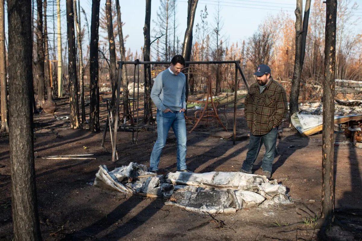 Prime Minister Justin Trudeau (L) tours Chaal Cadieux's devastated property from the wildfire in Enterprise, N.W.T., on Oct. 11, 2023. (The Canadian Press/Jason Franson)